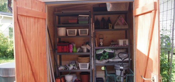 Puutarhavaja sisäpuolelta. Tavarat järjestyksessä hyllyillä.