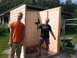 Nuori mies ja isänsä pystyttämässä puutarhavajaa