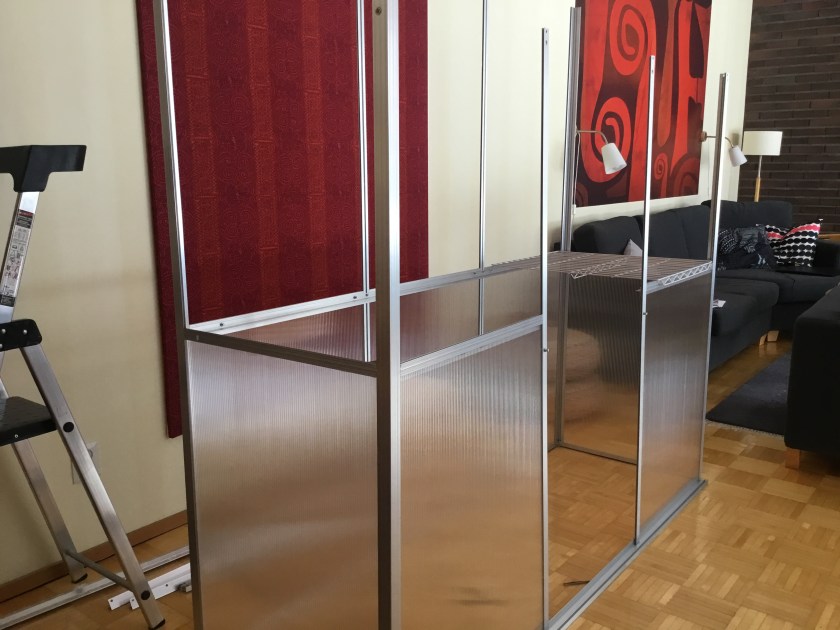 Seinämallinen keskeneräinen pieni kasvihuone. Alapaneelit paikoillaan.