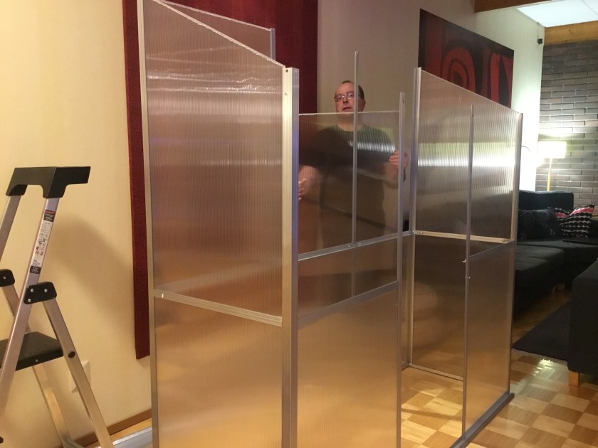 Seinämallinen keskeneräinen kasvihuone. Yläpaneelien kiinnitys meneillään.