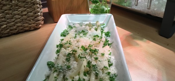 Keitettyjä mustajuuria vadilla, pinnalla silputtua persiljaa ja raastettua parmesaania.