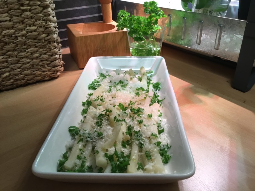 Keitettyjä mustajuuria vadilla, pinnalla silputtua persiljaa ja raastettua parmesaania.