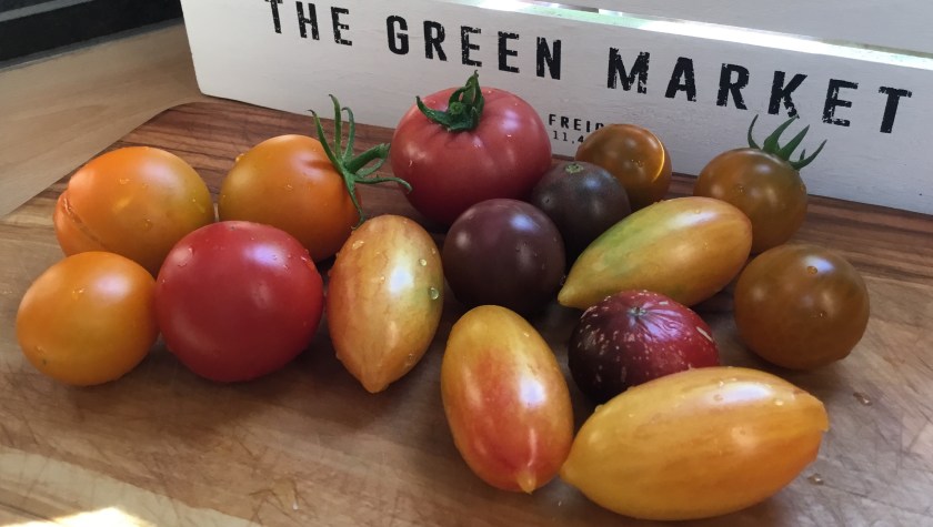 Erilaisia tomaatteja pöydällä.